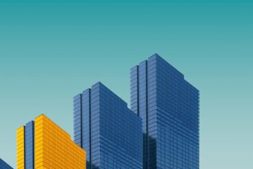 blue and yellow curtain wall building during daytime