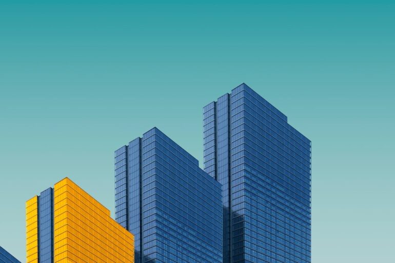 blue and yellow curtain wall building during daytime